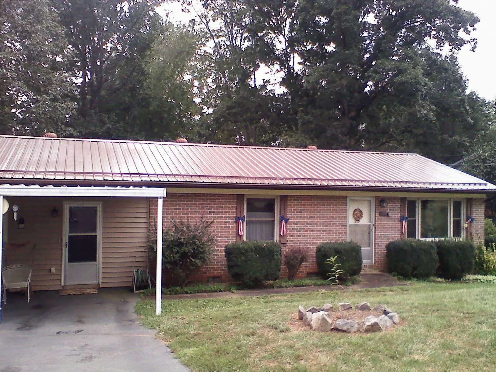 Bronze metal roof and carport on a brick ranch home — Roof Repair work by our crew in Livingston